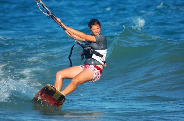 chica en el mar practicando kitesurf